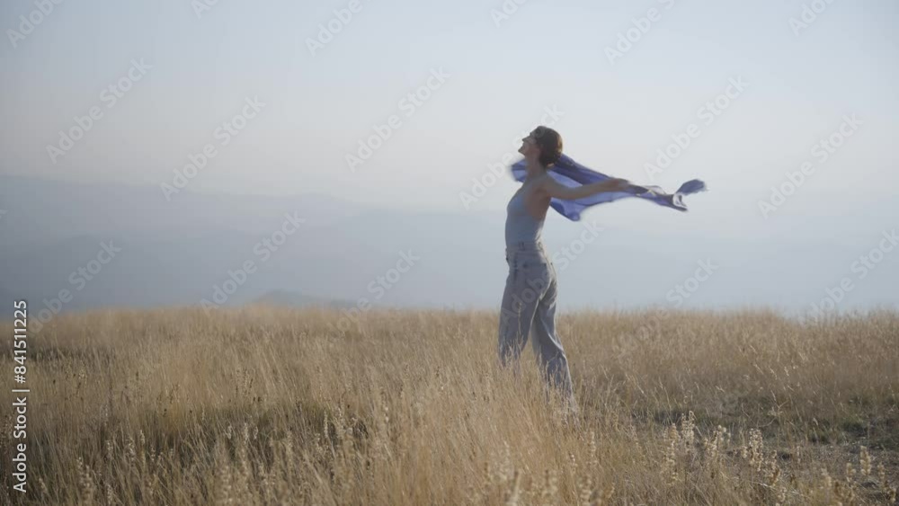 Woman standing on top of mountain at sunset holding the European Union flag Woman standing on top of mountain at sunset holding the European Union flag