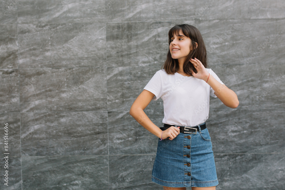 Pretty teen girl with braces in glasses posing near gray wall Pretty teen girl with braces in glasses posing near gray wall