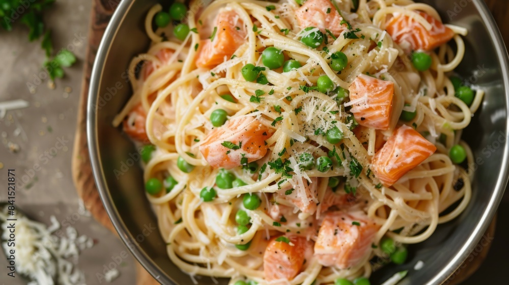 A rustic seafood pasta dish with al dente spaghetti tossed in a creamy sauce with chunks of salmon, peas, and Parmesan cheese A rustic seafood pasta dish with al dente spaghetti tossed in a creamy sauce with chunks of salmon, peas, and Parmesan cheese