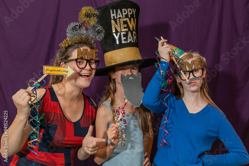 Canvas Print Mother and Two Daughters Posing with Photo Booth Props at New Year's Eve Party-