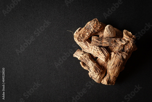 A pile of Dry Organic Sweet flag or Vach (Acorus calamus) roots, isolated on a black background. Top view photo