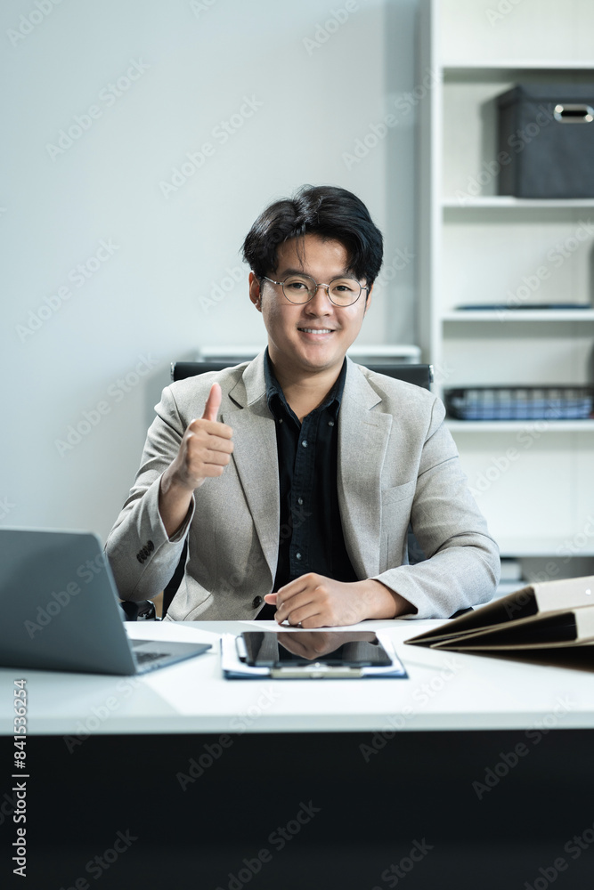 Young businessman sitting at his desk in the office. Young businessman sitting at his desk in the office.
