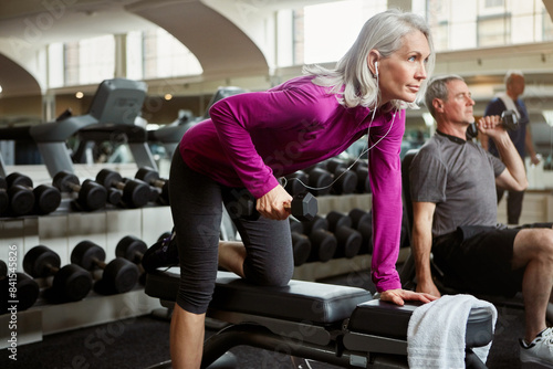 Fototapeta Naklejka Na Ścianę i Meble -  Workout, weights and senior woman in gym for fitness, training and cardio exercise listen to music. Retirement, sports and person with dumbbells for wellness, muscle strength and mobility for health