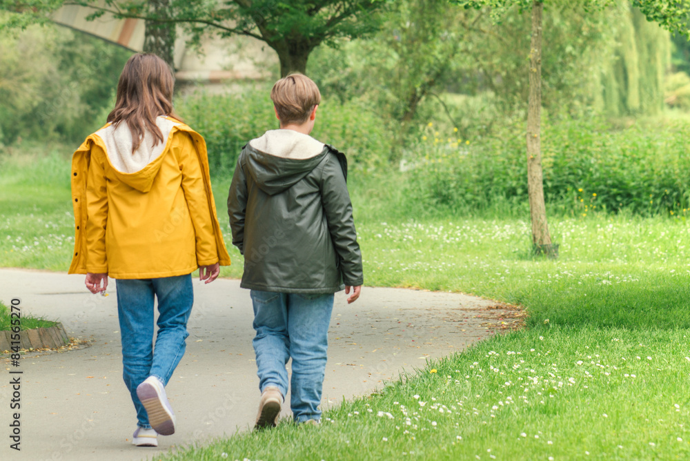 A boy and a girl 10-12 years old are walking together in the park. Teen friendship A boy and a girl 10-12 years old are walking together in the park. Teen friendship