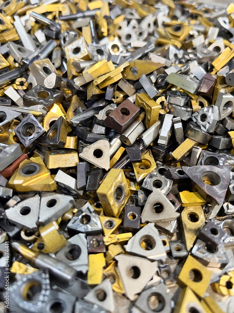 Scrap Tungsten cutting tips after use on an industrial lathe, ready to be recycled Scrap Tungsten cutting tips after use on an industrial lathe, ready to be recycled