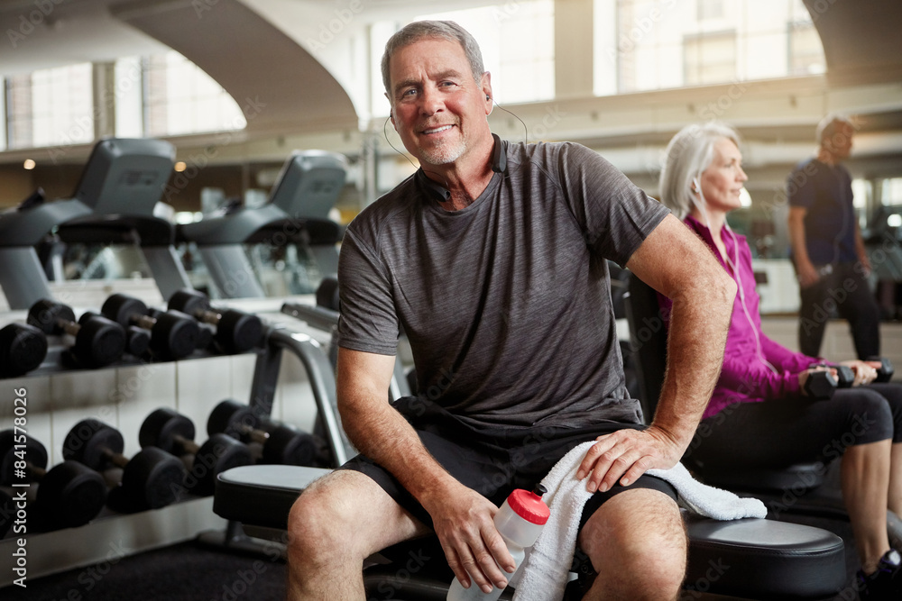 Fitness, music and portrait of old man in gym with water bottle for training, exercise and workout. Sports, retirement and person with listening to music, audio and radio for wellness, rest or health Fitness, music and portrait of old man in gym with water bottle for training, exercise and workout. Sports, retirement and person with listening to music, audio and radio for wellness, rest or health