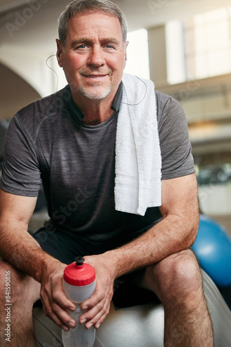 Relax, fitness and portrait of mature man with smile, gym and happiness with water bottle at workout. Exercise, training and confident athlete on break with pride, health and wellness in sports club.