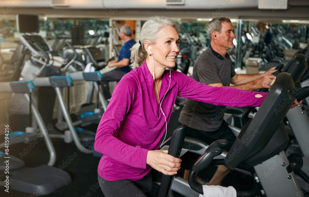 Woman, earphones and exercise machine for workout, sports and music for performance or action. Female person, stationary and equipment at gym for fitness, sound and streaming radio for cardio bike Woman, earphones and exercise machine for workout, sports and music for performance or action. Female person, stationary and equipment at gym for fitness, sound and streaming radio for cardio bike