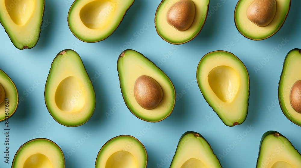 Halved avocados arranged on a blue background. Food and healthy life theme. Design for print, poster, packaging. Halved avocados arranged on a blue background. Food and healthy life theme. Design for print, poster, packaging.