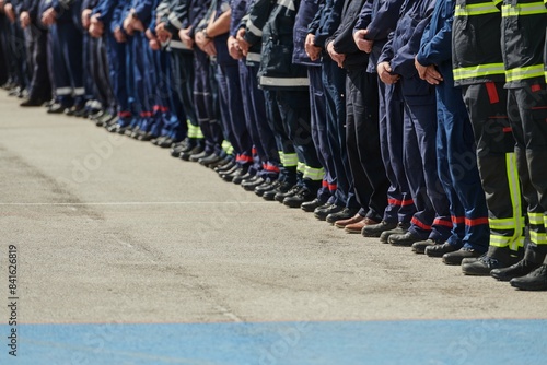 Foto A group of firefighters lined up, saluting the flag, applauding in solidarity, and gearing up for intensive training sessions, showcasing their unwavering commitment to service and teamwork