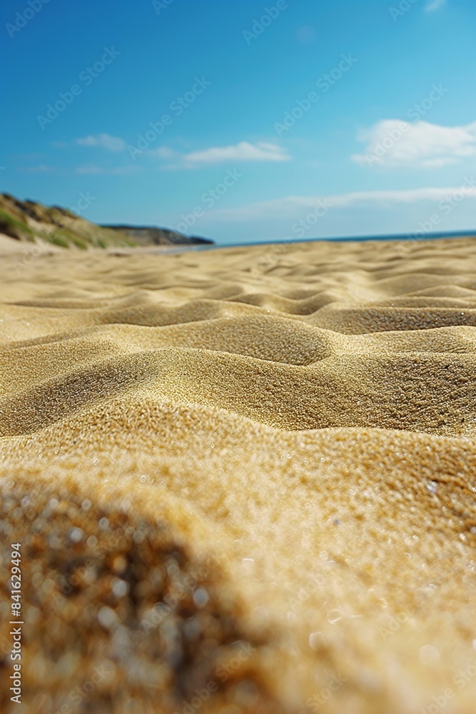 Closeup of golden sand dunes on a sunny beach with the ocean and sky in the background. Summer and travel theme. Design for poster, wallpaper, banner with copy space. Closeup of golden sand dunes on a sunny beach with the ocean and sky in the background. Summer and travel theme. Design for poster, wallpaper, banner with copy space.