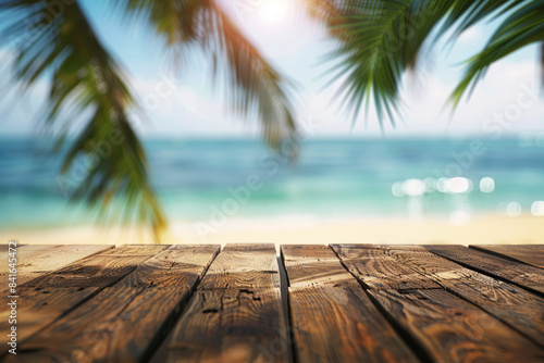 Wooden deck overlooking a tropical beach with palm leaves and ocean in the background