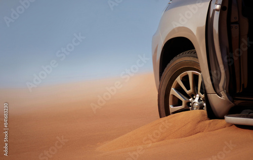 Close up of a golden car stuck in the sand in the Namib desert.