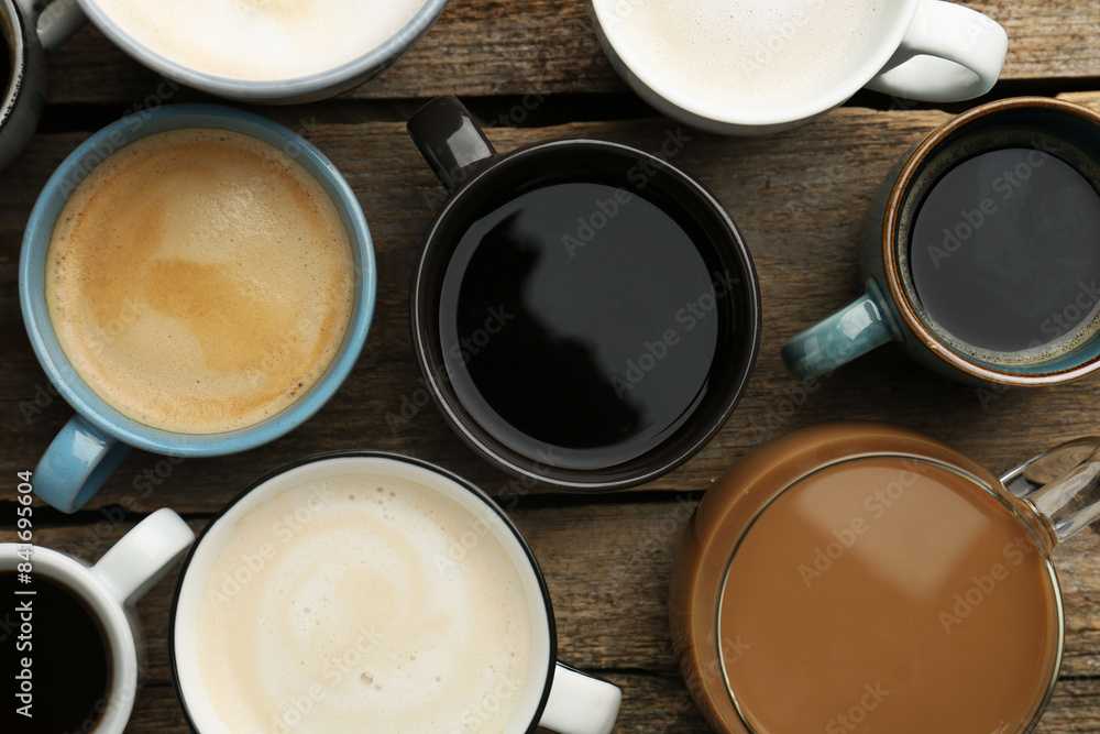 Different coffee drinks in cups on wooden table, flat lay Different coffee drinks in cups on wooden table, flat lay