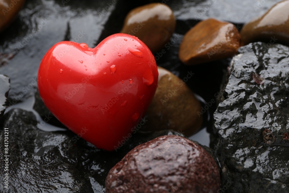 Red decorative heart on stones and water, closeup Red decorative heart on stones and water, closeup