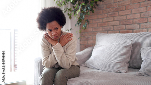 African American woman sitting at home, feeling miserable and depressed photo