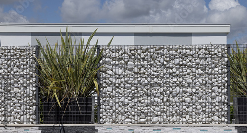 Brise-vue en gabions de galets blancs en aluminium d'une maison	 photo