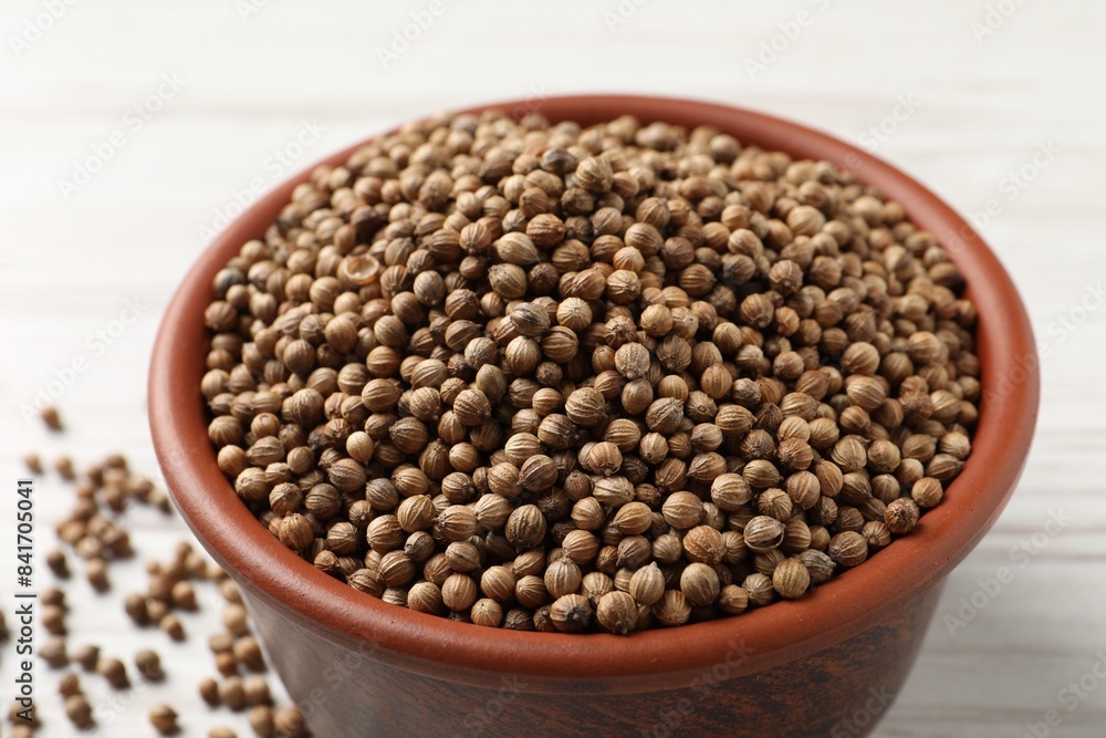 Dried coriander seeds in bowl on light table, closeup Dried coriander seeds in bowl on light table, closeup