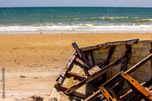 Looking over the bow of an old and weathered boat stranded on the sandy beach at Inhassoro in Mozambique.