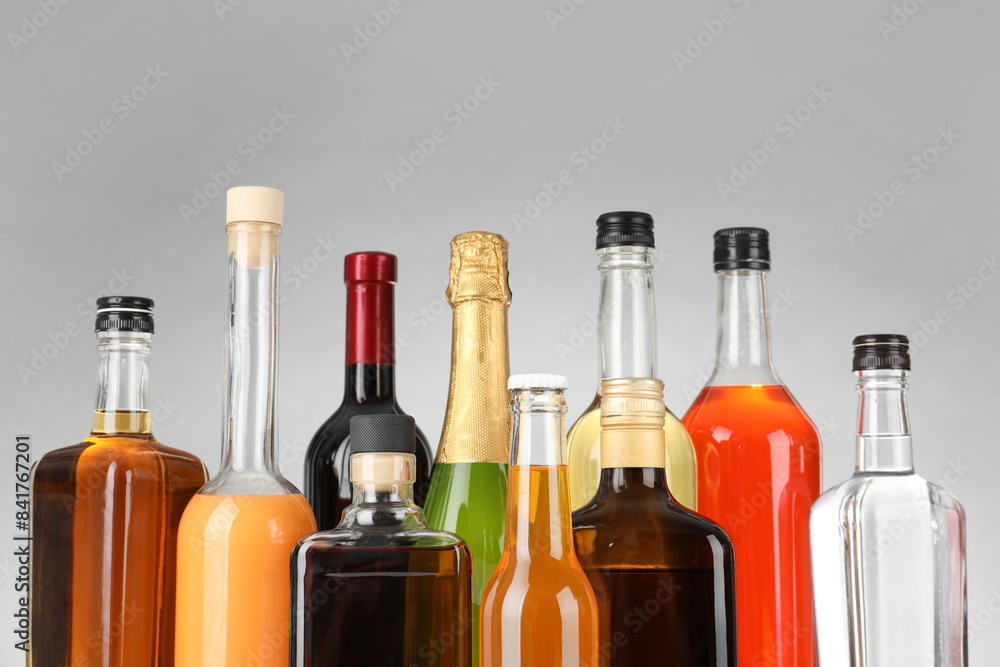 Bottles of different alcoholic drinks on gray background, closeup Bottles of different alcoholic drinks on gray background, closeup