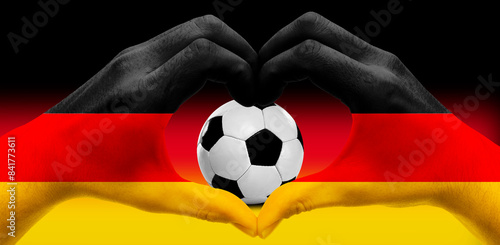 Hand formt ein Herz um Fussball