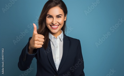 Confident Businesswoman Giving Thumbs Up in Front of Blue Background