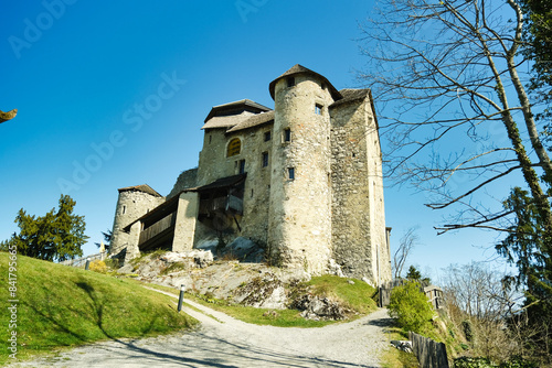 A large stone building with a steeple sits on a hill photo