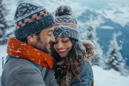 Portrait of a content indian couple in their 30s dressed in a warm ski hat isolated on pristine snowy mountain