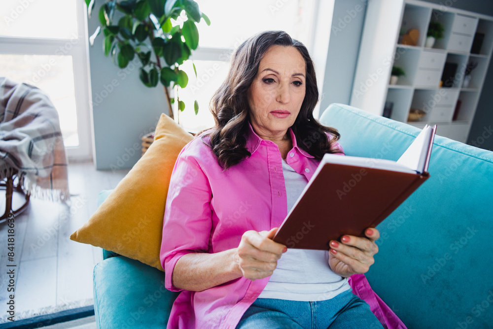Photo of adorable lovely retired woman sitting couch reading book weekend hobby comfy indoors Photo of adorable lovely retired woman sitting couch reading book weekend hobby comfy indoors