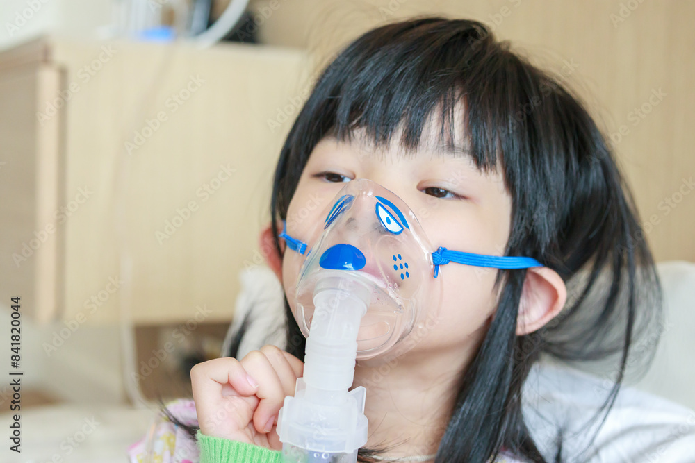 Sick little asian girl inhalation with nebulizer for respiratory treatment Sick little asian girl inhalation with nebulizer for respiratory treatment