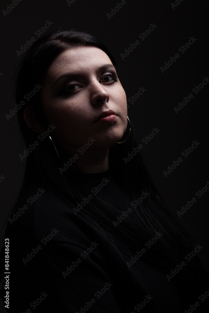 Side lit silhouette portrait of a girl looking at camera against black background Side lit silhouette portrait of a girl looking at camera against black background