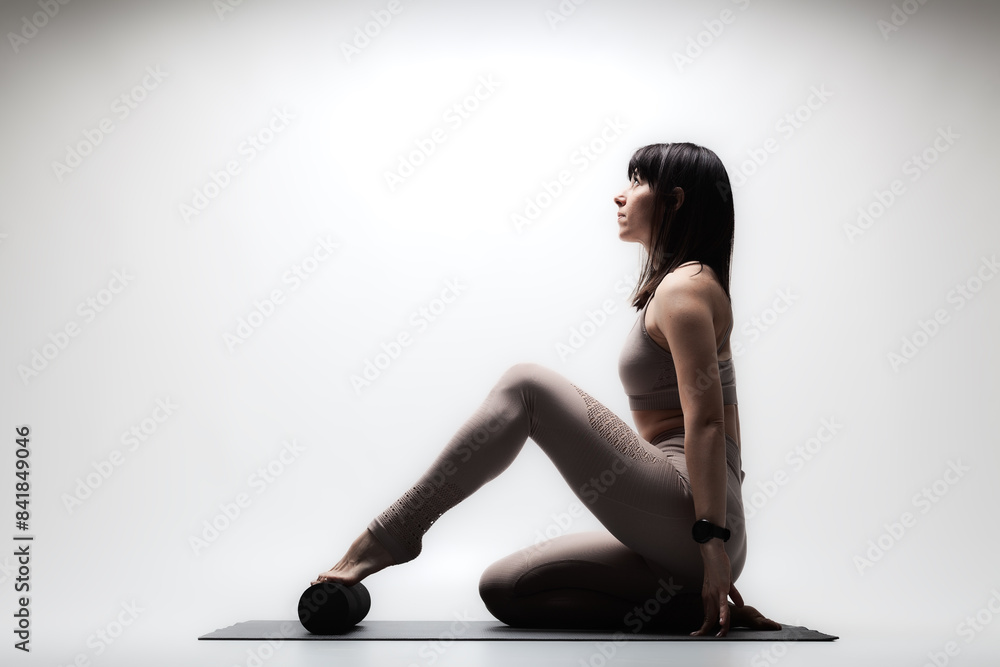 Fototapeta premium Beautiful caucasian woman in yoga pose. Half silhouette shot of a girl making stretching exercises.