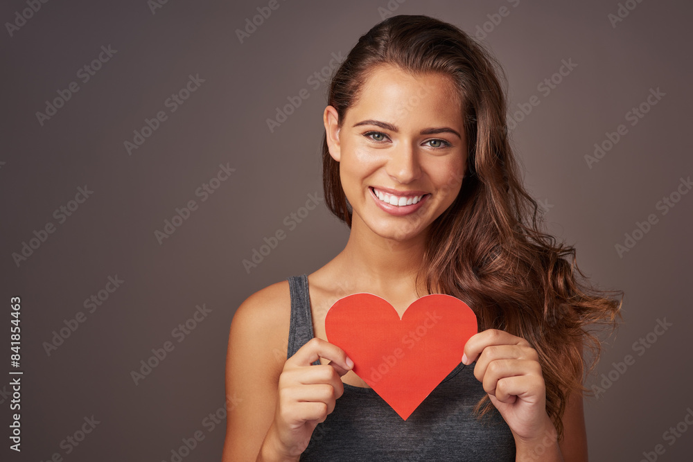 Portrait, happy and woman with paper heart in studio for romance, support and care isolated on background. Face, smile and model with love sign for valentines day, kindness and emoji for social media Portrait, happy and woman with paper heart in studio for romance, support and care isolated on background. Face, smile and model with love sign for valentines day, kindness and emoji for social media