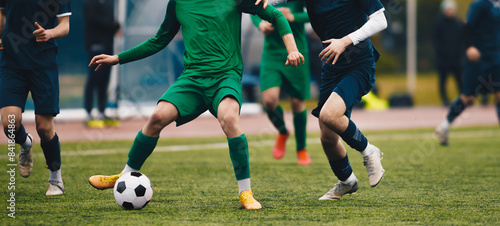 Adult soccer football player kick a ball during match in the stadium. Soccer forward dribbling ball. Footballers in action on the tournament game. Adult football competition