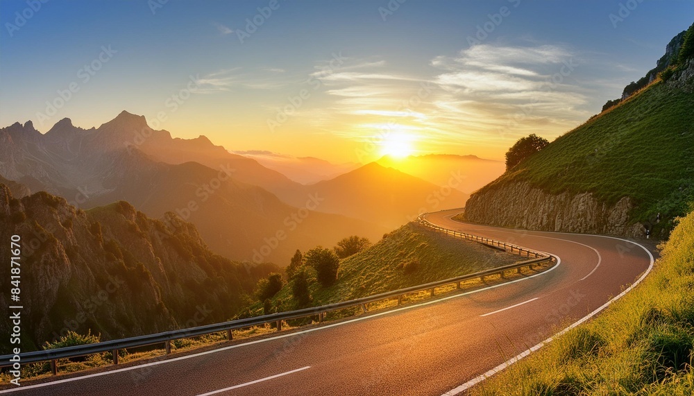 sunrise over a mountain landscape and a paved road offering a wide vista