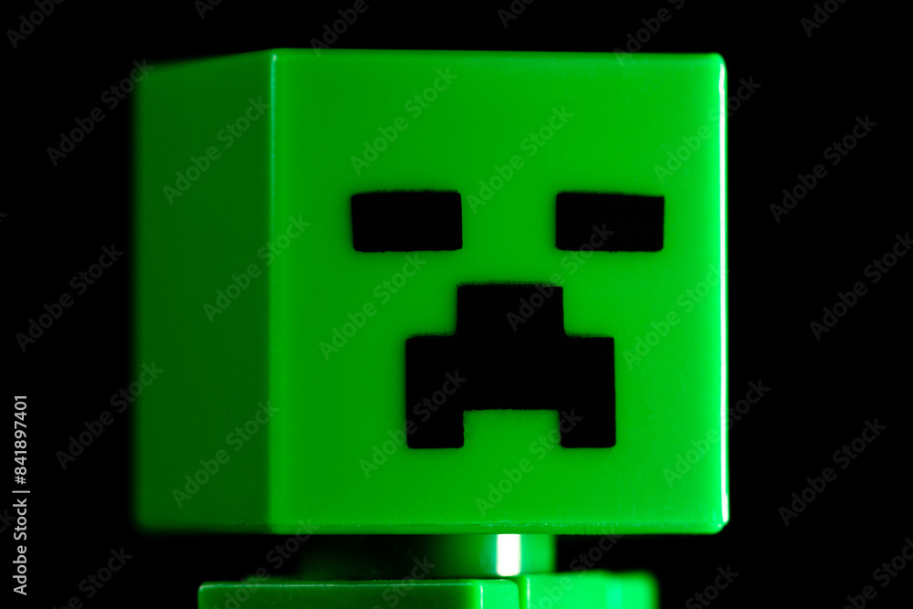 Naklejka premium Face of LEGO Minecraft green Creeper Mob on the black background