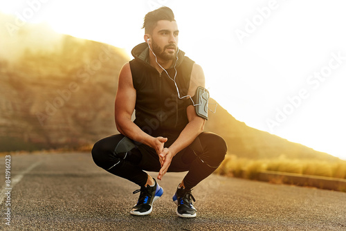 Sunset, man and thinking with music in countryside for fitness and exercise in summer. Mountain, athlete and bodybuilder in nature for wellness and idea for workout with health podcast in California