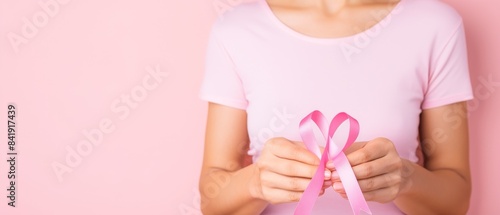 Wallpaper Mural A woman is holding a pink ribbon in her hand, which is a symbol for breast cancer awareness Torontodigital.ca