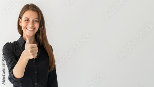 Joyful young woman gives thumb up, isolated on light grey background. Copy space, 16:9 photo