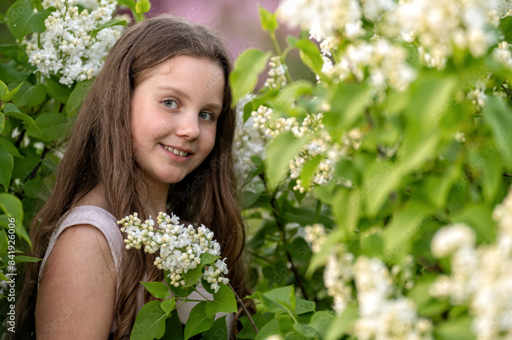 Girl in a lilac bush. Background with selective focus and copy space Girl in a lilac bush. Background with selective focus and copy space