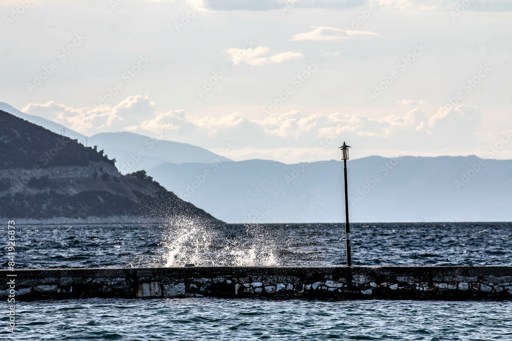 Waves crashing against a rock on the coast. Waves crashing against a rock on the coast.