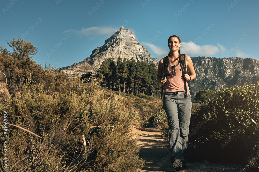 Naklejka premium Portrait, hiking and woman with nature, walking and outdoor for adventure, wellness and journey. Person, hiker and healthy girl with environment, mountain and cardio with vacation, energy and travel