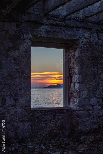 Sunset through abandoned building window Croatian coastline 