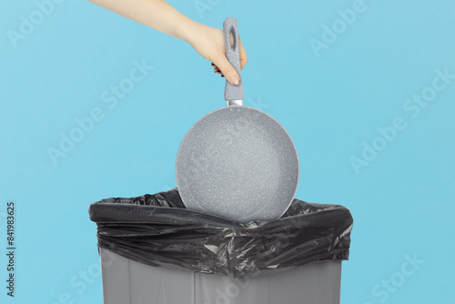Photography throw the frying pan in the trash, outstretched hand with the frying pan in fron