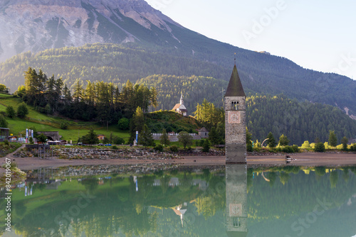 Lake Reschensee and mountain alps panorama with steeple (bell tower) of submerged church in South Tyrol, Italy photo