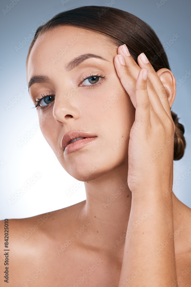 Naklejka premium Woman, portrait and skincare in studio, soft and cosmetics to pamper on blue background. Female person, makeup and transformation or facial treatment for glow, dermatology and smooth or clear skin