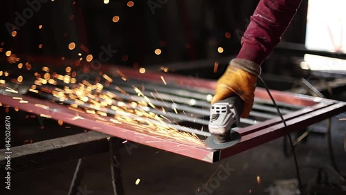 Industrial professional worker grinding metal. Sparks fly from hot metal. Slow motion.
Craftsman use saw cutting machine to cut metal detail. Man with circular saw sawing steel in garage or workshop.  photo