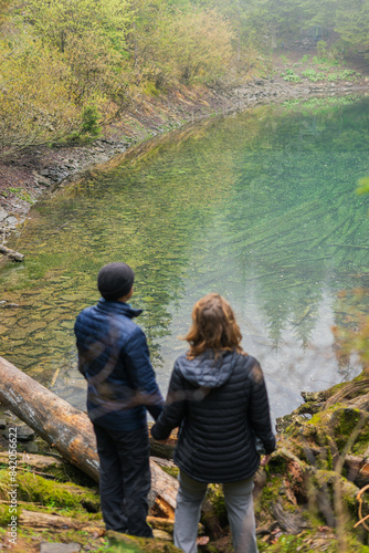 couple man and woman looking at the lake in the forest in the middle of the mountains, dating, family, time together, values, holding hands, joint rest, blue clear water, Rosokhan in the Carpathians photo