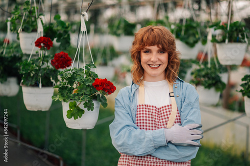 Close up of successful entrepreneur standing at glasshouse near flowers