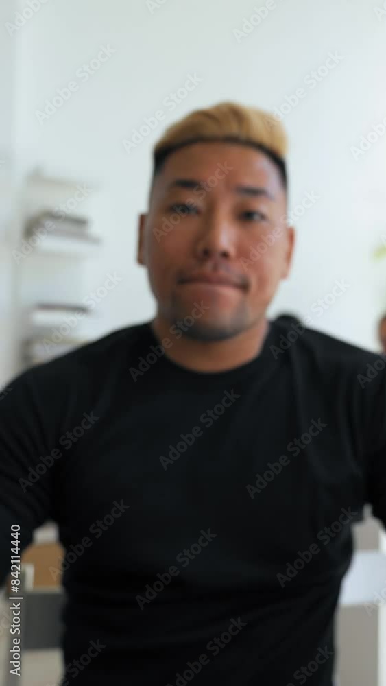 POV of Asian man dyed blond coming in office after break to continue online communication. Young employee talks on video call with colleague closeup Vertical Shot. POV of Asian man dyed blond coming in office after break to continue online communication. Young employee talks on video call with colleague closeup Vertical Shot.